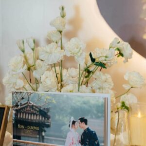 Album ảnh cưới trên bàn đón khách hoa trắng