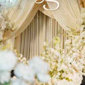 Monogram D&S trên rèm kem champagne sân khấu tiệc cưới
