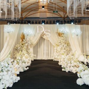 Tiệc cưới Thùy Dương Thế Sơn sân khấu rèm kem champagne monogram D&S lối đi hoa trắng