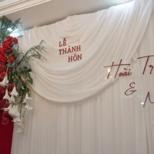 Backdrop gia tiên Lễ thành hôn Hoài Trung Mai Chi vải trắng hoa đỏ