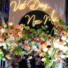 Neon tên Việt Dũng Ngọc Mai trên sân khấu tiệc cưới hoa pastel