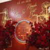Backdrop cưới màu đỏ gold chữ hỷ vòng tròn đèn hắt hoa hồng đỏ lễ ăn hỏi Vũ Ngọc Anh Nguyễn Việt Cường