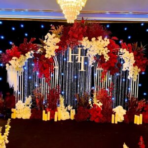 Backdrop cưới màu đỏ monogram HH rèm pha lê vòm hoa đỏ trắng đèn chùm phông sao