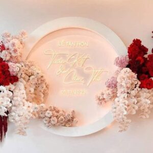 Backdrop neon đám cưới Tuấn Kiệt Cẩm Thơ chữ vàng ấm vòng acrylic hoa đỏ hồng