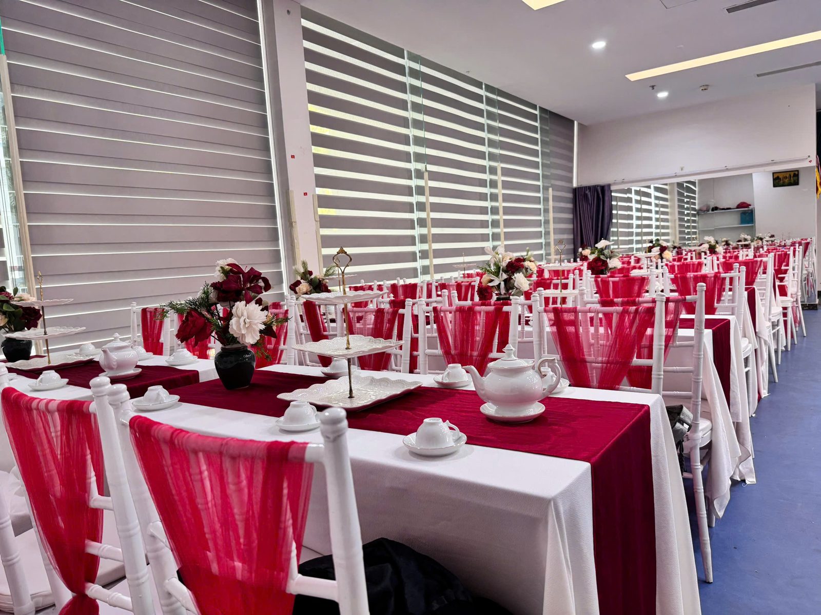 Bàn dài khăn trắng phủ runner đỏ, ghế Tiffany voan đỏ kê cho tiệc trà