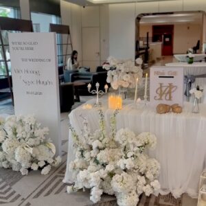 Bàn lưu niệm hoa trắng và bảng welcome trước sảnh tiệc