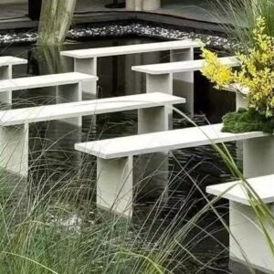 Cận ghế băng trắng chân chìm dưới bể nước nông cụm lan vàng rêu xanh cỏ lau