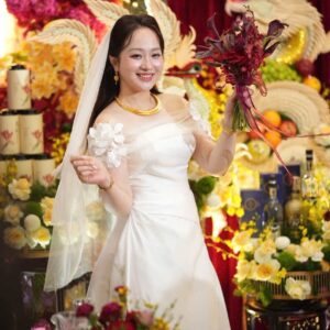 Chụp ảnh cô dâu áo dài ngày cưới cầm hoa đỏ trước gia tiên rồng phượng lễ đính hôn