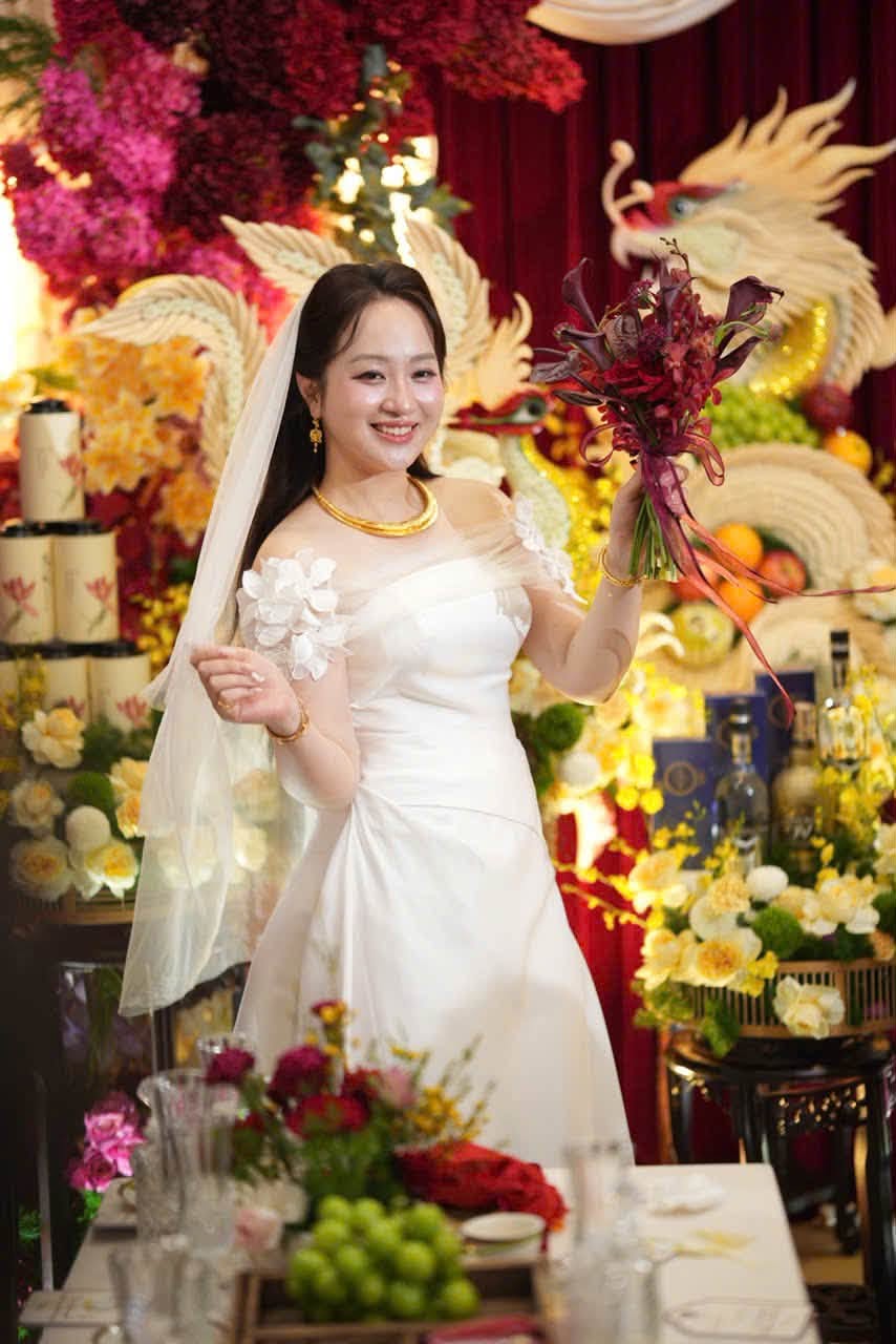 Chụp ảnh cô dâu áo dài ngày cưới cầm hoa đỏ trước gia tiên rồng phượng lễ đính hôn