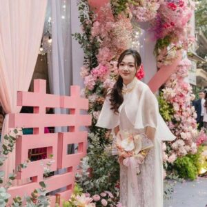 Chụp ảnh cô dâu áo dài ngày cưới nửa người bên chữ hỷ hồng cắt khối hoa hồng