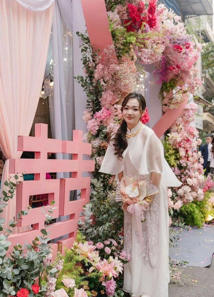 Chụp ảnh cô dâu áo dài ngày cưới nửa người bên chữ hỷ hồng cắt khối hoa hồng