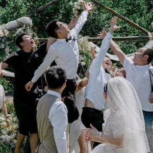 Chụp ảnh cưới ngoài trời bạn bè tung chú rể lên cao cạnh vòm tre cô dâu cười