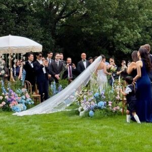 Chụp ảnh cưới ngoài trời cô dâu đi vào lễ đuôi voan dài trên cỏ khách vỗ tay
