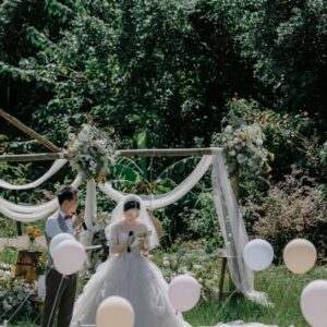 Chụp ảnh cưới ngoài trời cô dâu trao lời thề dưới vòm tre voan trắng bóng bay pastel