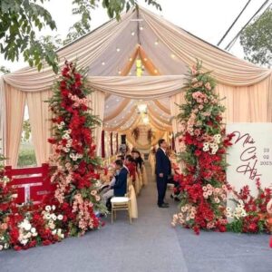 Cổng hoa cao đỏ hồng kem đầu rạp kéo dọc ngõ bảng Nhà có hỷ