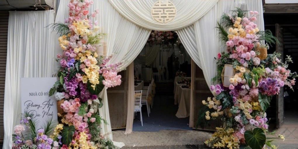 Cổng vải trắng chữ hỷ tròn kem trụ hoa pastel lan tím vàng hồng bảng Nhà có hỷ Phương Anh Đức Minh