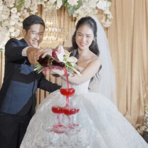 Khoảnh khắc đẹp ngày cưới cô dâu chú rể rót tháp rượu đỏ sân khấu rèm kem
