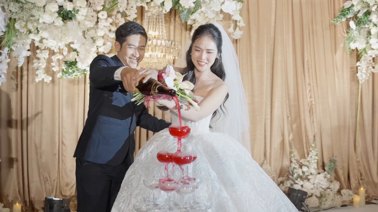Khoảnh khắc đẹp ngày cưới cô dâu chú rể rót tháp rượu đỏ sân khấu rèm kem