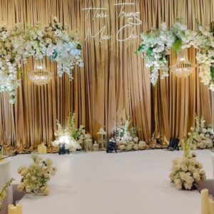 Lối đi trắng dẫn tới sân khấu sảnh cưới tone champagne hoa kem nến trụ