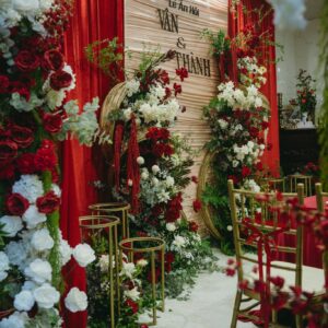 Lối vào phòng khách cột hoa trắng đỏ đôn vàng ghế chiavari lễ ăn hỏi Vân Thành