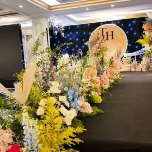 Monogram đám cưới T&H gold trên đĩa tròn lối đi hoa vàng nhiều màu