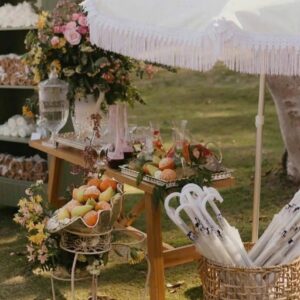 Quầy đồ ăn nhẹ dưới ô trắng tua rua giỏ mây đựng ô trắng cho khách tiệc cưới ngoài trời