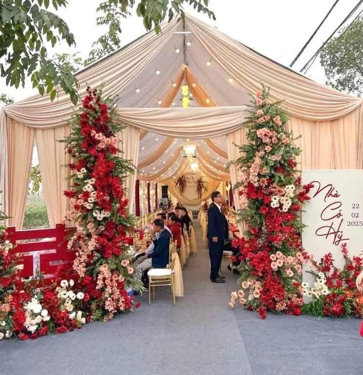 Rạp cưới vải kem cột hoa đỏ hồng bảng Nhà có hỷ 22.02.2025 lễ thành hôn Bùi Hân Ngọc Anh