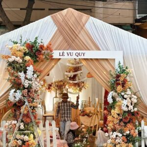 Rạp lễ vu quy be cam khung chéo mái vải hoa cam trắng ngoài phố