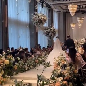 Sảnh khách sạn vách kính hoa treo trần đèn chùm lối hoa quay chụp tiệc cưới