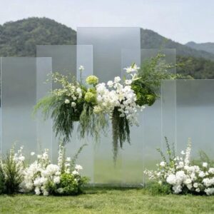 Tấm acrylic mờ xếp chồng so le cụm hoa trắng treo ngang cỏ đuôi chồn rủ đám cưới bên hồ