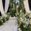 Tiệc cưới tone xanh lá trắng tường lá greenery monogram PH rèm trắng lối đi hoa trắng