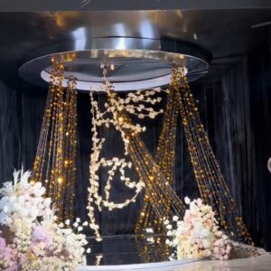 Trang trí sảnh cưới đèn chùm sân khấu mái tròn rèm hạt vàng monogram dây hoa vàng nền đen