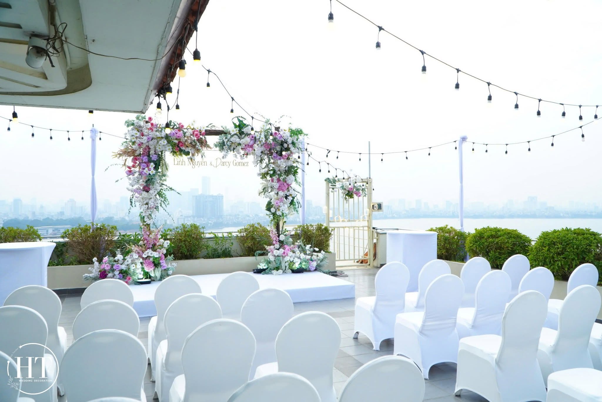 Ghế trắng, cổng hoa và dây đèn trên rooftop trong lễ cưới Linh Nguyễn và Darcy Gomez